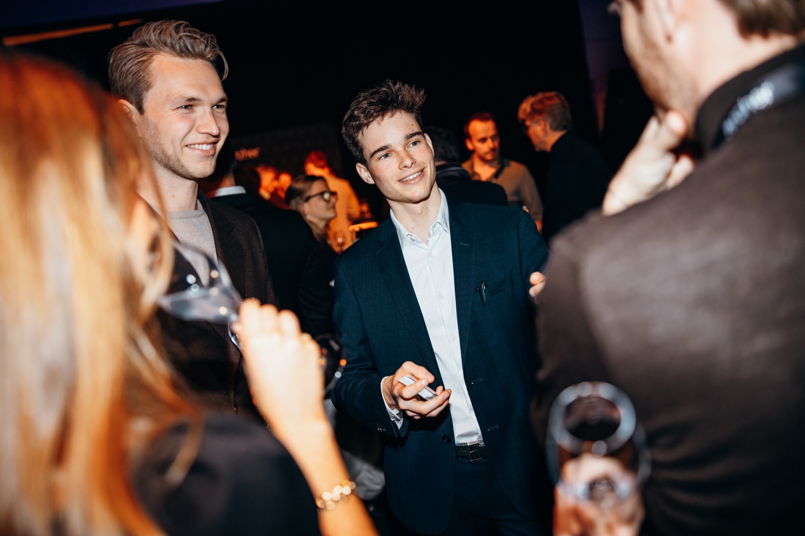 A guest smiling during close-up magic at a corporate evening reception