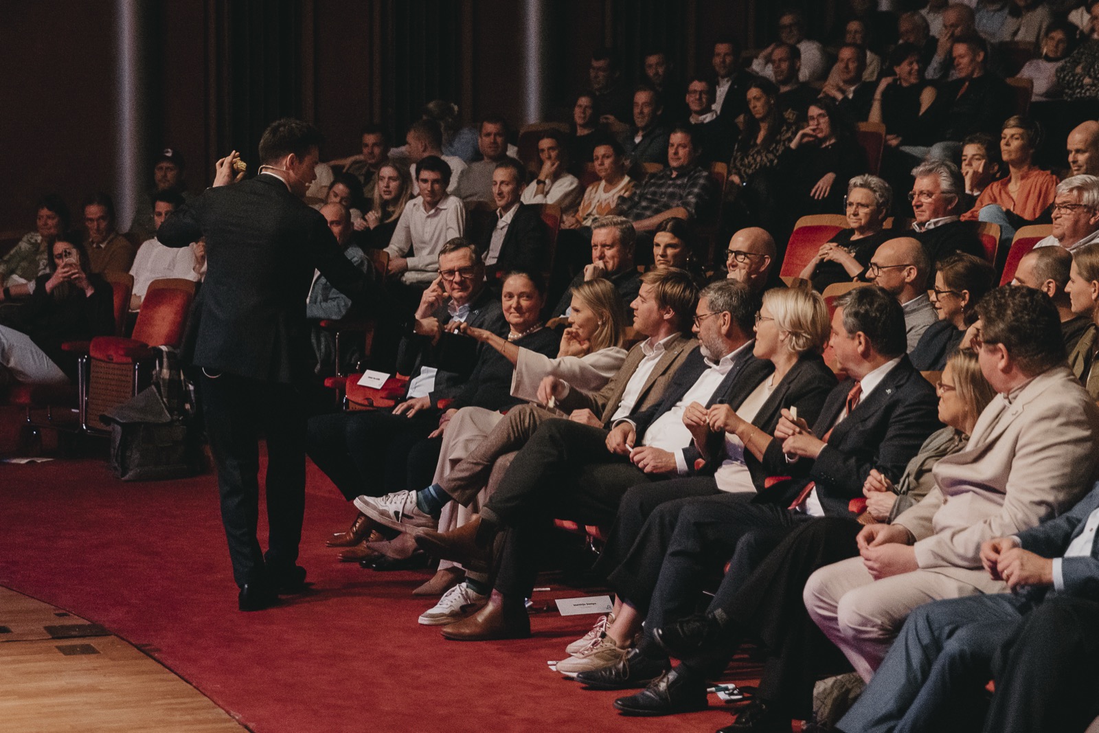 A corporate audience reaching out to interact during a theatre performance