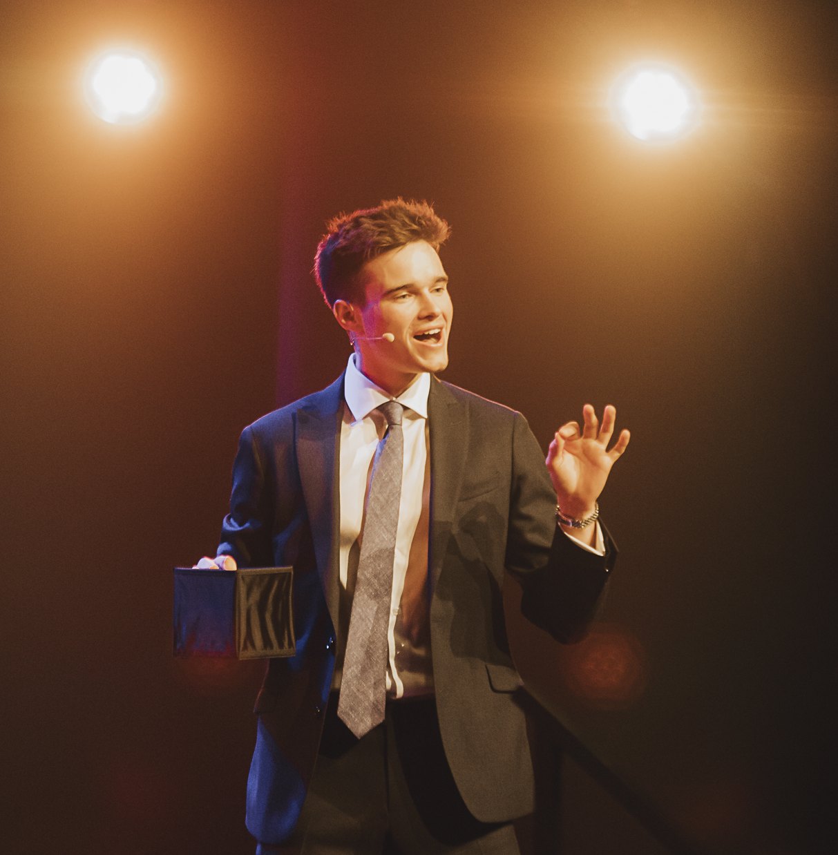 Jonas De Bruyn speaking on stage under warm spotlights, a portrait for the leadership keynote
