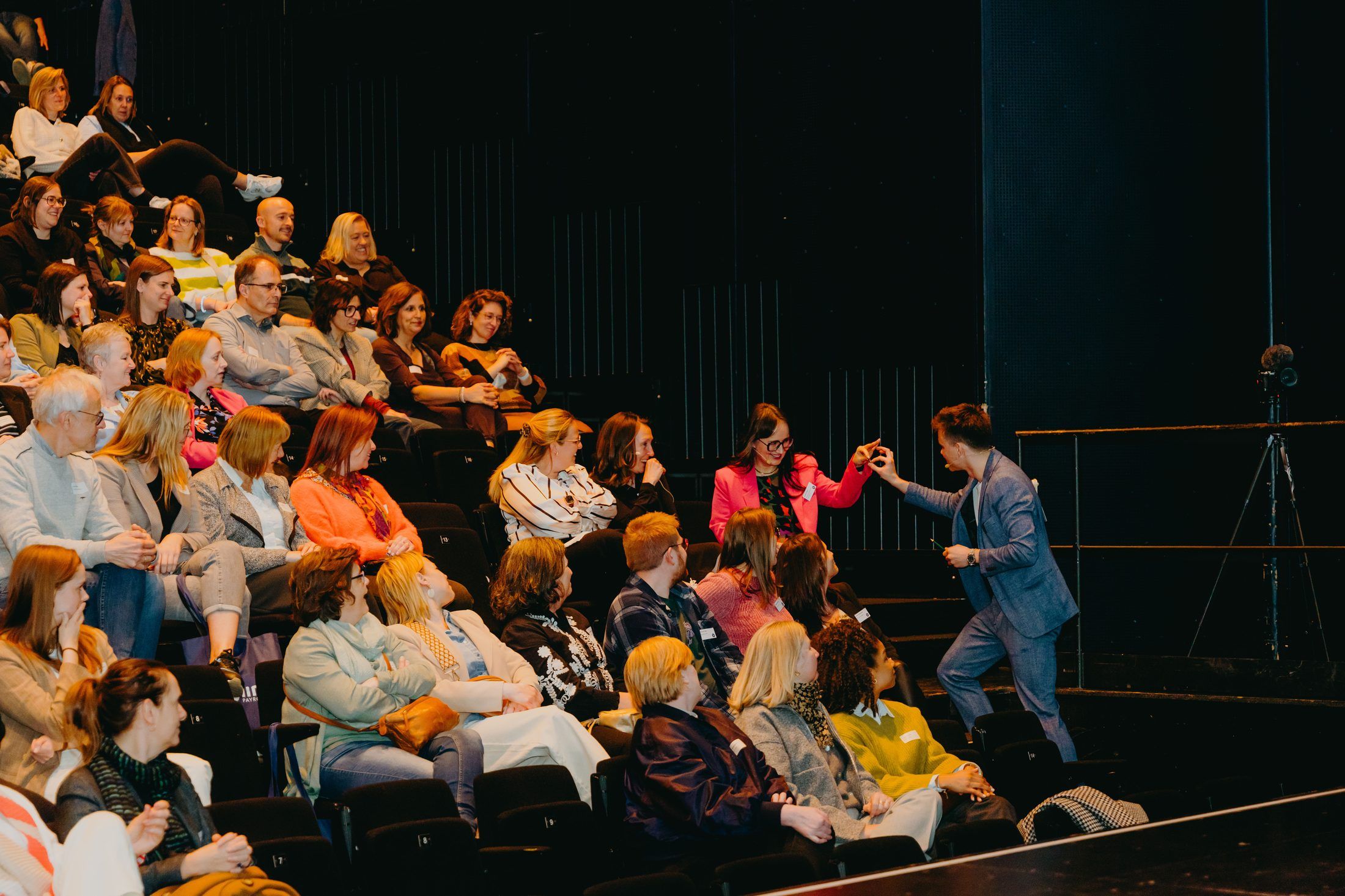 Jonas De Bruyn connecting with a delighted executive audience member in a theatre